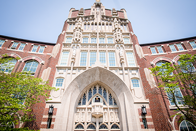 student poses on Harkins Hall balcony