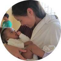 Student holds a baby on an outreach trip in Jamaica