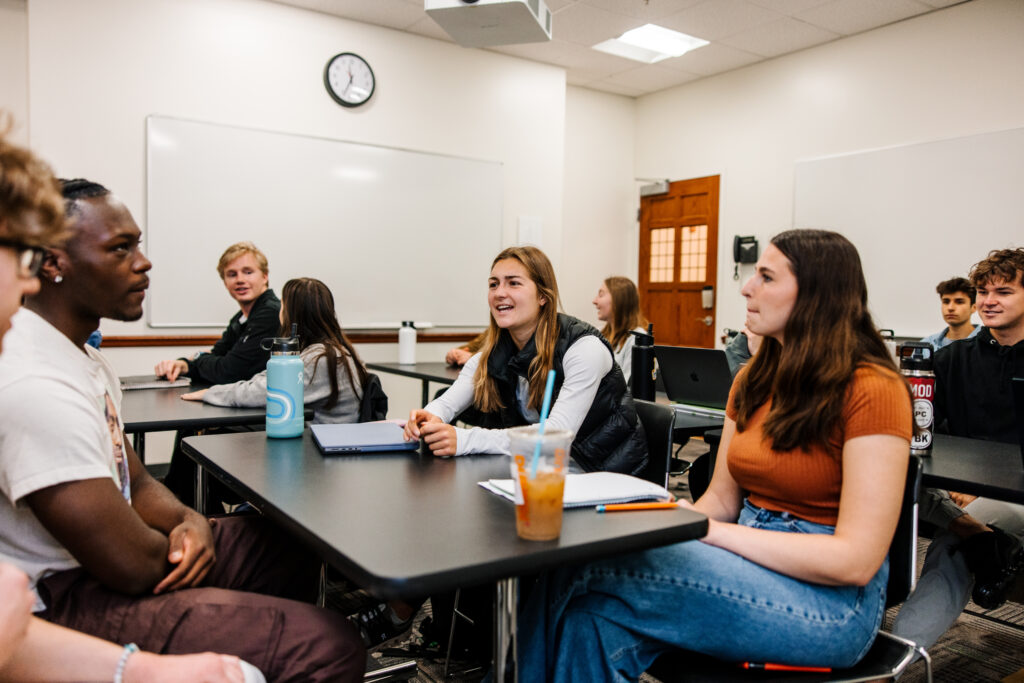 Students conversing in a classroom at Providence College